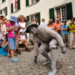 Living statue performer with crowd